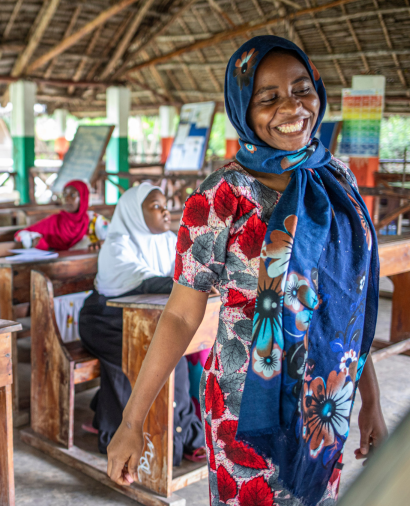 Local Community member wearing traditional dress in classroom setting at an African Impact Base