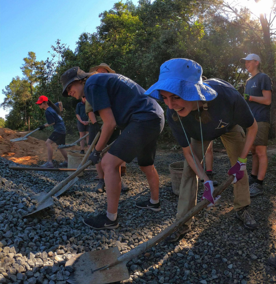 Student travellers with spades working on project work on a Camps International School Expedition