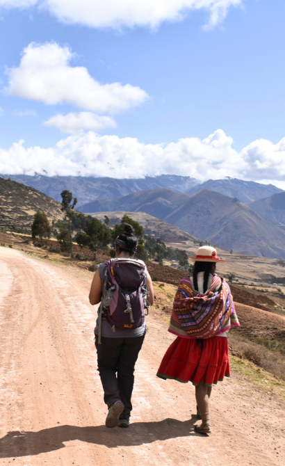 Young traveller walking with community member in Peru
