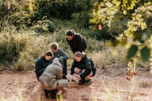 Volunteers looking at tracks in the African bush