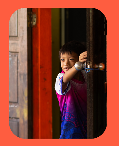 young boy peeping out of the doorway