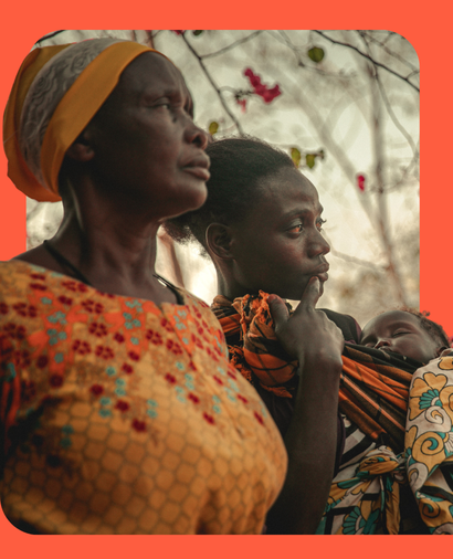 Two Ladies from the Tumani Women's Group in Kenya with baby in traditional dress