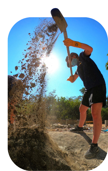 Young adult on project work with spade mixing cement